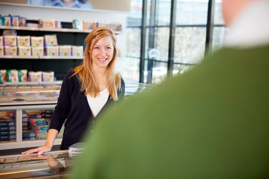 a woman smiling and flirting with a man in a supermarket