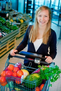 A portrait of a happy female shopper in a supermarket