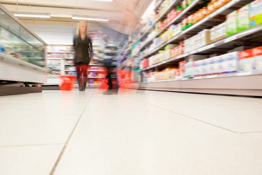 Blurred view of people in supermarket while shopping