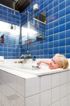 A woman taking a luxury bath cure in a old 20s style spa