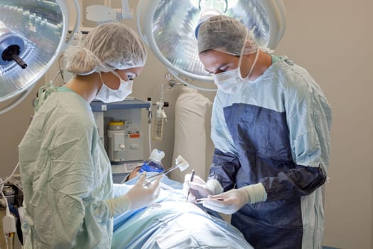 Medical doctor performing an operation on patient in operating room
