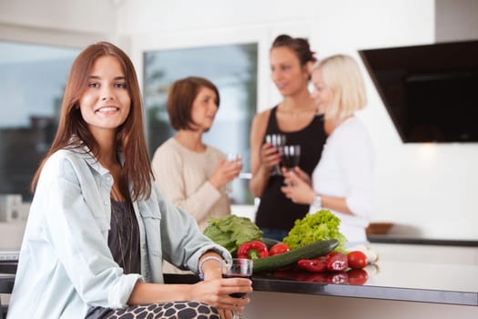 Portrait of woman holding drink with female friends in background