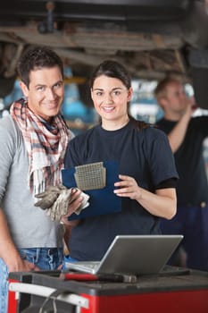 Portrait of female mechanic worker standing with customer