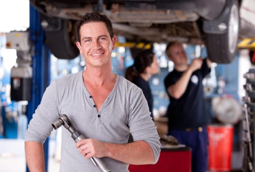 Portrait of a mechanic holding an air powered socket