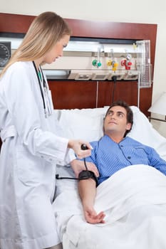 Doctor checking the blood pressure of young patient in hospital