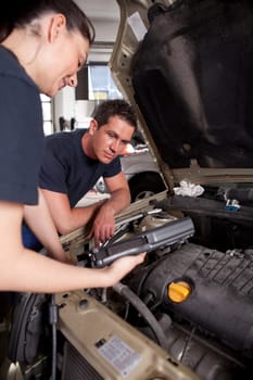 A team of mechanics using an electronic diagnostics tool