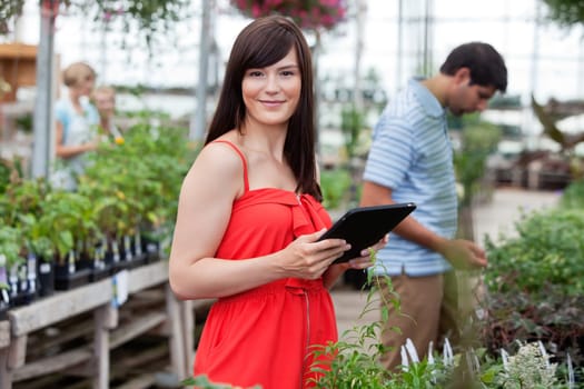 Attractive woman holding tablet pc with people in background