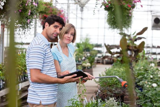 Customer asking female worker a question using a digital tablet