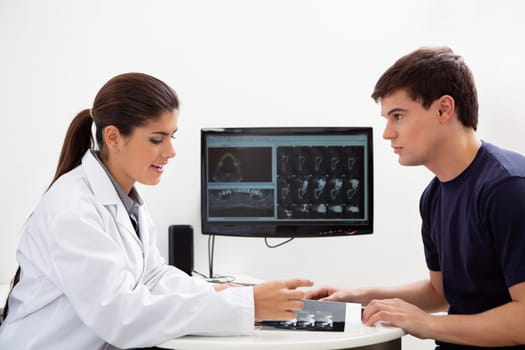 Female dentist discussing report with patient at clinic