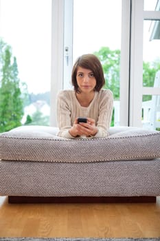 Portrait of a serious looking female holding cell phone