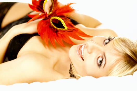 Portrait of attractive beautiful young woman on bed with red mask