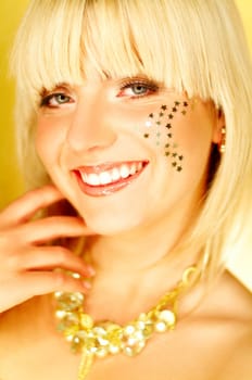 Portrait of beautiful young smiling woman with red lipstick and golden stars on chick