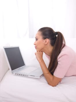 Young pretty women on white couch relaxing and using laptop computer