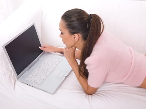 Young pretty women on white couch relaxing and using laptop computer