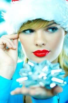 Beautiful young woman wearing santas hat next to christmas tree on white background