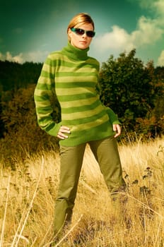 Young business woman relaxing on golden meadow at mountains outdoors