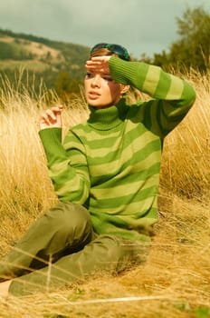 Young business woman relaxing on golden meadow at mountains outdoors
