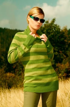 Young business woman relaxing on golden meadow at mountains outdoors