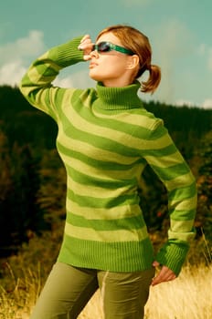 Young business woman relaxing on golden meadow at mountains outdoors