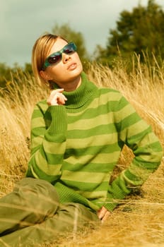 Young business woman relaxing on golden meadow at mountains outdoors