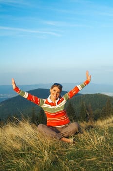 Young beautiful woman relaxing on meadow at mouintain outdoors
