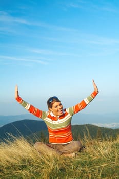 Young beautiful woman relaxing on meadow at mouintain outdoors
