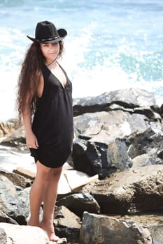 Young woman in black hat near the ocean