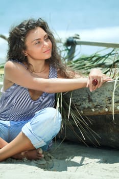 Young beautiful fisherwoman with boat on the beach