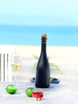 Bottle and glass of wine on the beach