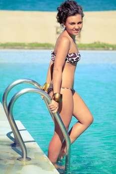 Beautiful curly woman at the swimming pool