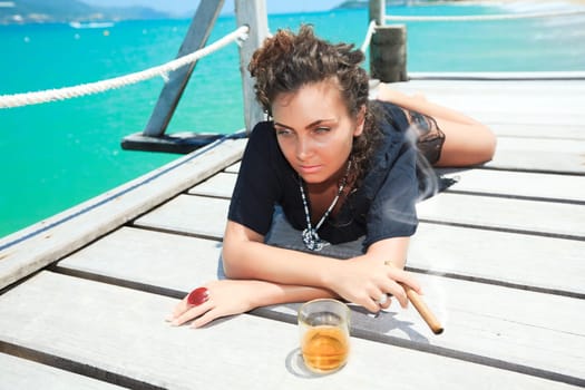 Young woman with cigar and a glass of whiskey