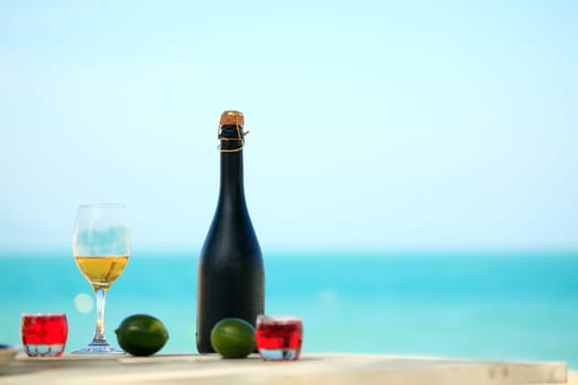 Bottle and glass of wine on the beach
