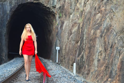 Woman is going from the railway tunnel