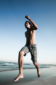 Young handsome man is running on the beach