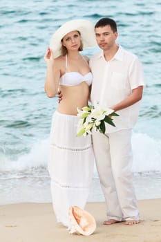 Romantic couple near the ocean with flowers
