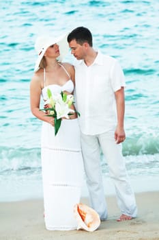Romantic couple near the ocean with flowers
