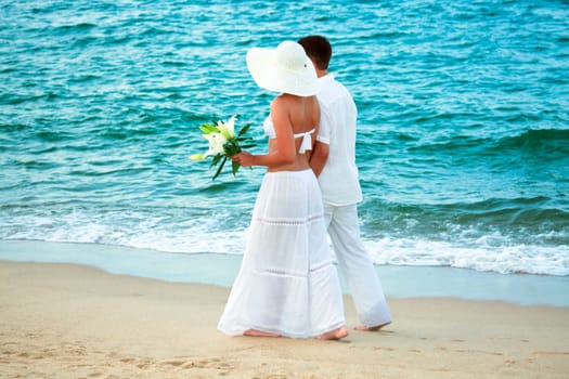 Romantic young couple walking along the sea