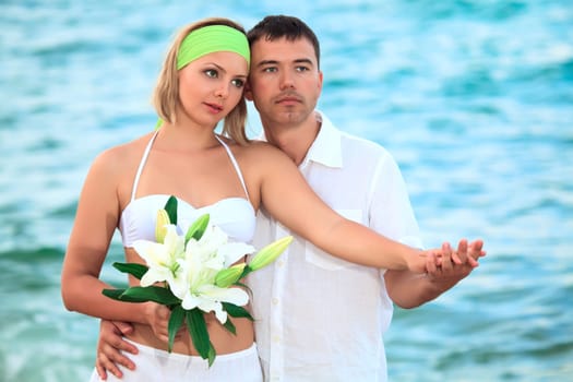 Romantic couple near the ocean with flowers