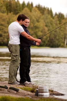 A man and woman fishing on a forest lake