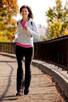 A young woman jogging on a path in a park