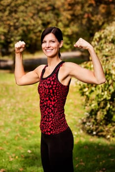 A portrait of a woman flexing her bicep muscles