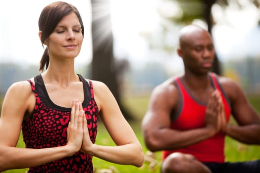 A group of people peacefully meditating in a park