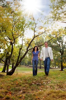 A happy couple walking in the park - looking at the camera