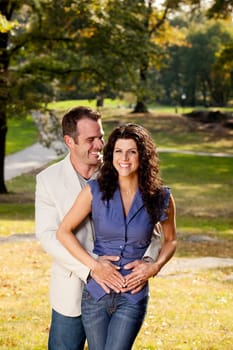 A happy couple in the park hugging