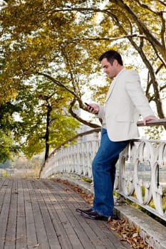 A man checking his cell phone in a park