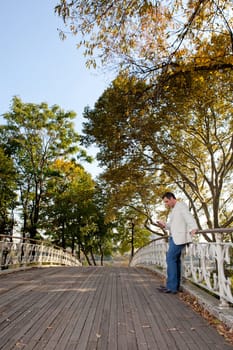 A man checking his cell phone in a park