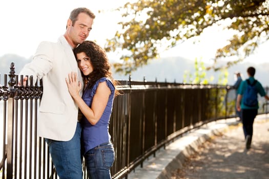 A couple huggnig in the park on a path