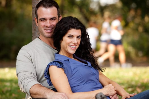 A happy married couple relaxing in the park - focus on the woman