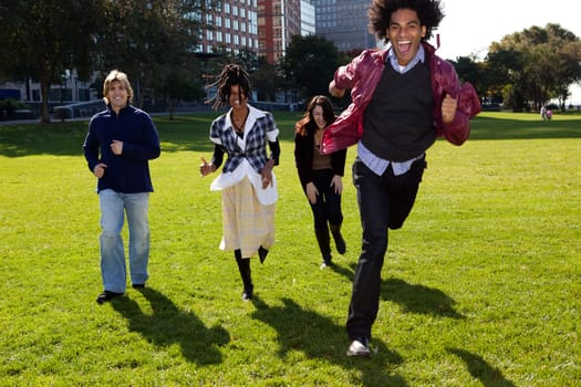 Four people running in urban park. Vertically framed shot.