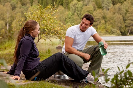 A couple cooking and making food outdoors on a camping trip
